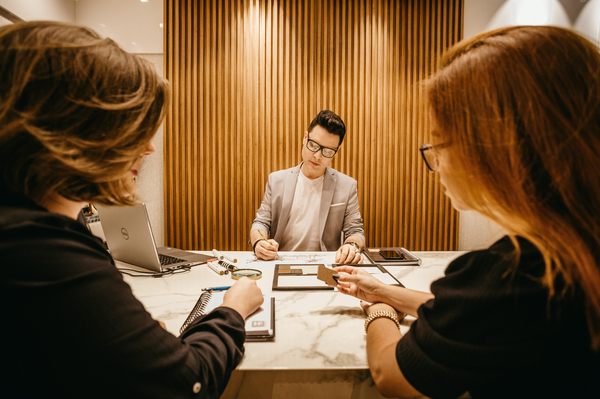 Three people in a mediation meeting at opposite ends of the table